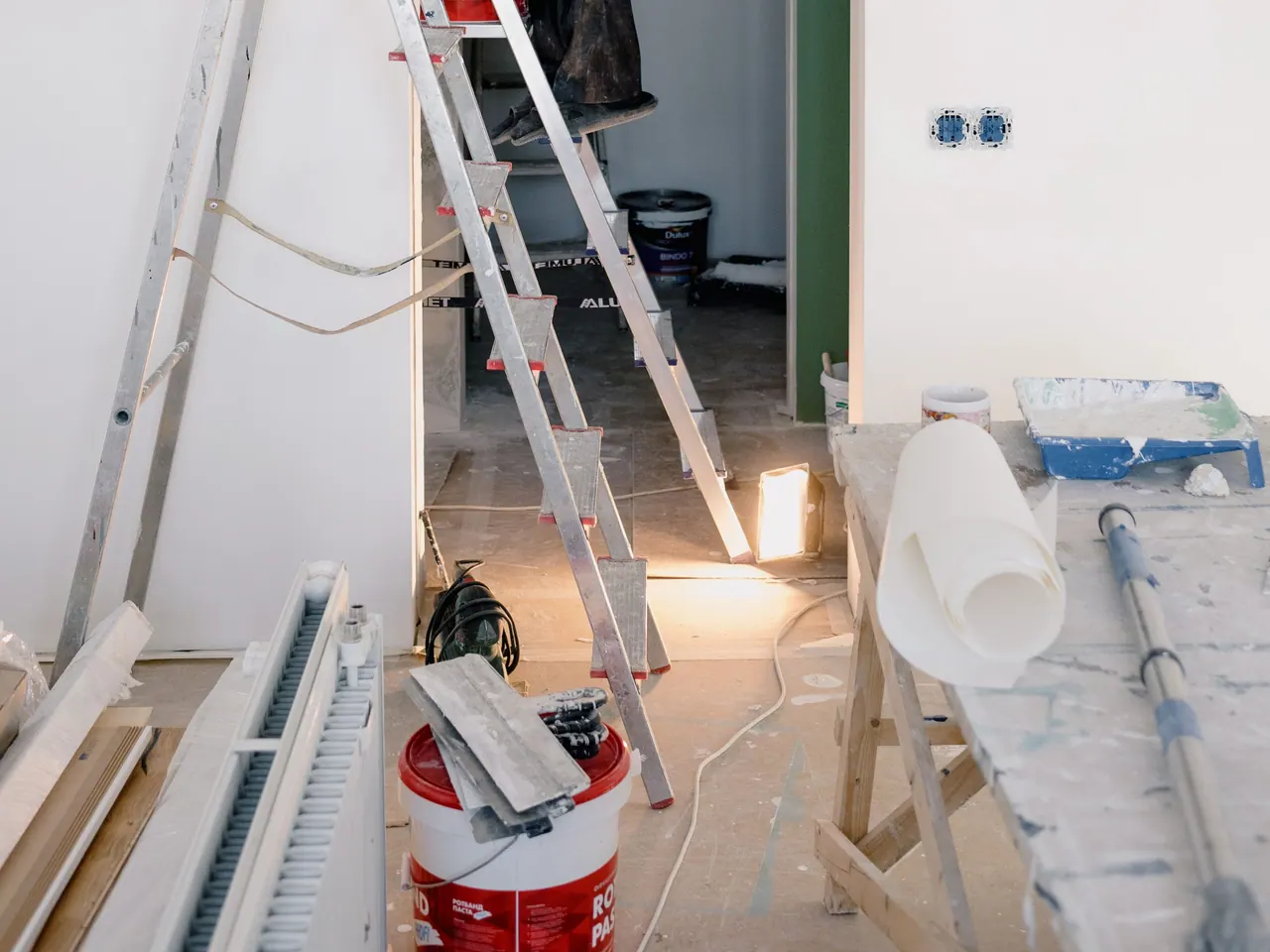 Leerer Raum mit Stehleiter und Malerwerkzeug während der Renovierung